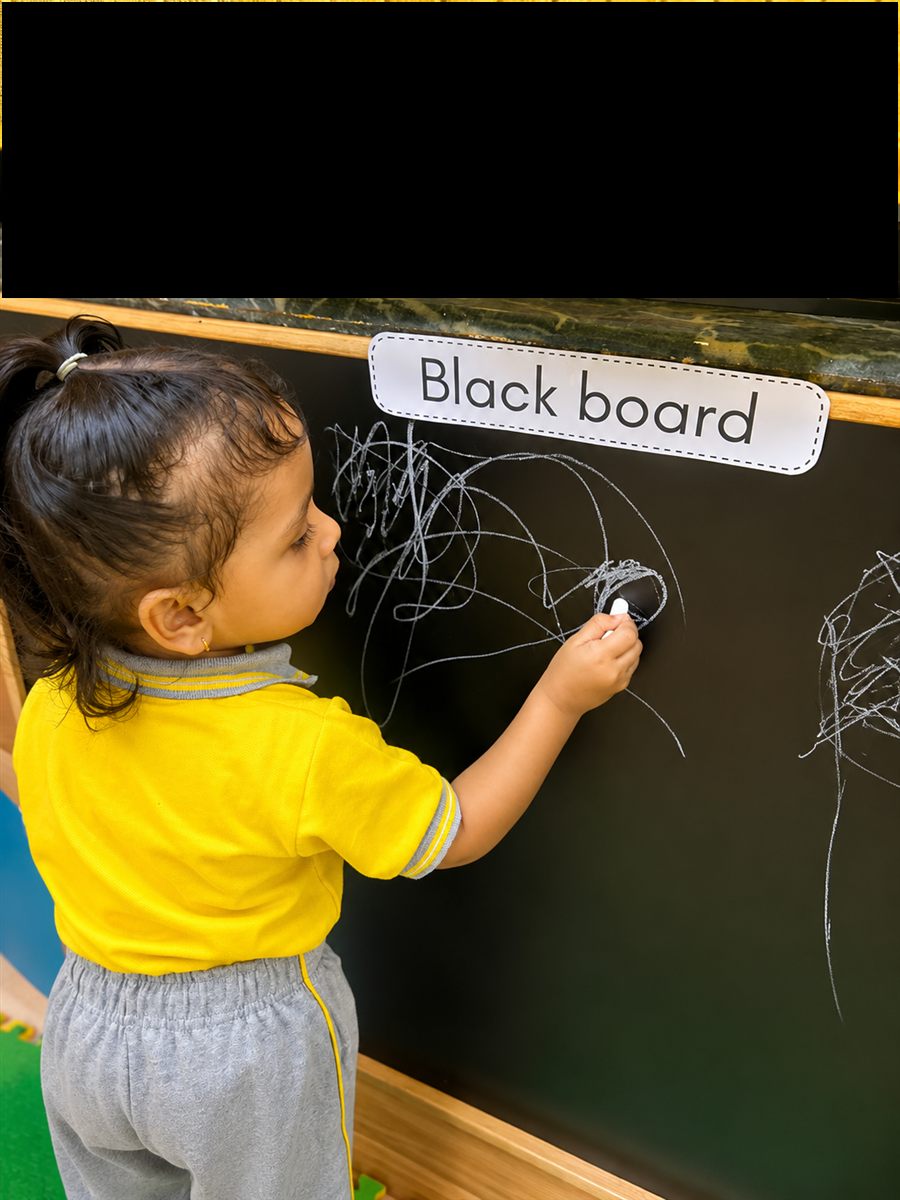 A child practising letters on a slate board