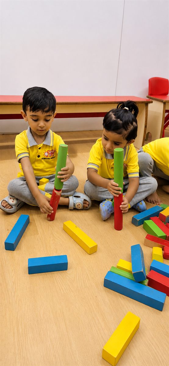 Two children exploring colourful stacking rods together